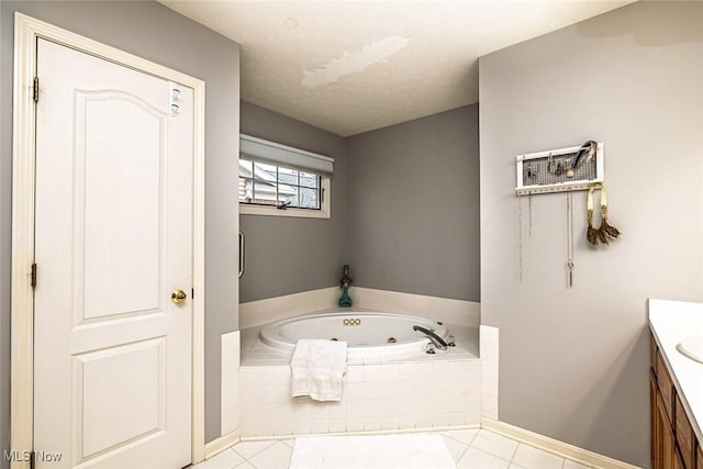 bathroom with a whirlpool tub, tile patterned flooring, vanity, and baseboards