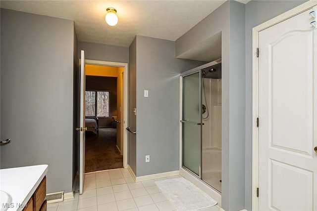 full bath featuring a shower stall, vanity, baseboards, and tile patterned floors