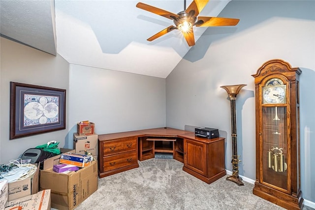 carpeted office featuring lofted ceiling, ceiling fan, and baseboards