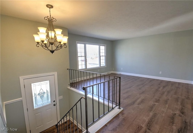 entrance foyer featuring baseboards, a chandelier, and dark wood-style flooring