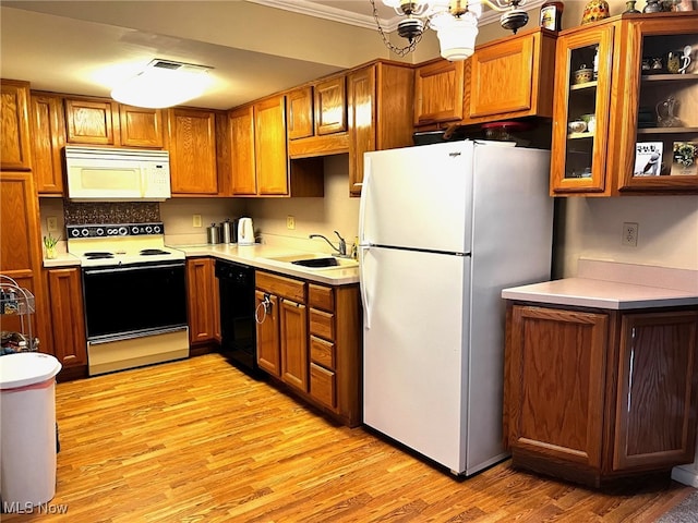 kitchen with white appliances, brown cabinets, and a sink