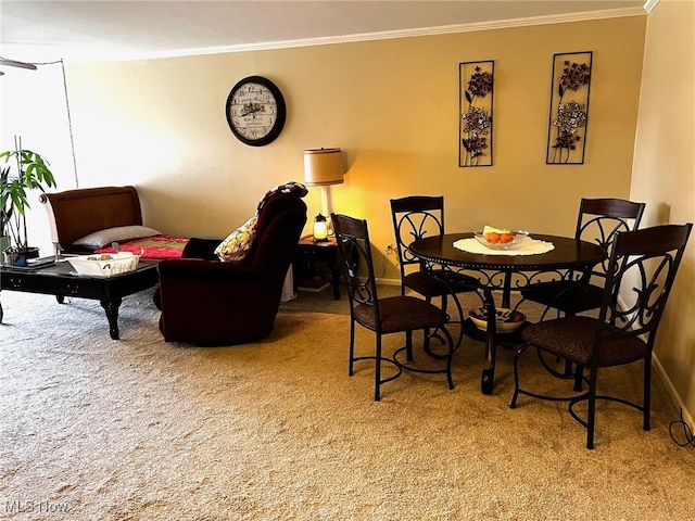 carpeted dining space with ornamental molding and baseboards