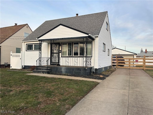 bungalow-style home featuring a porch, a shingled roof, a front yard, a gate, and fence