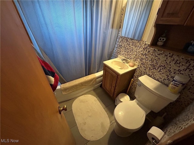 full bath with shower / bath combo, toilet, tile patterned flooring, vanity, and backsplash