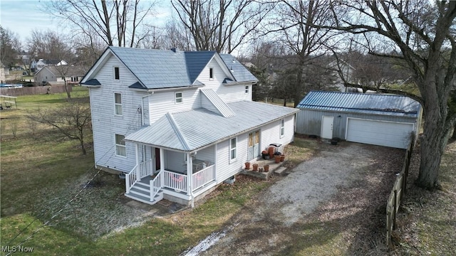 exterior space with a garage, metal roof, a porch, and an outdoor structure