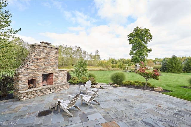 view of patio featuring an outdoor stone fireplace