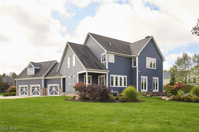 view of front of home featuring a garage, driveway, a barn, and a front lawn