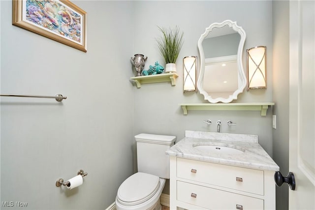 half bath featuring toilet and vanity