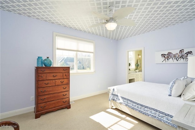 bedroom featuring a ceiling fan, light colored carpet, connected bathroom, and baseboards