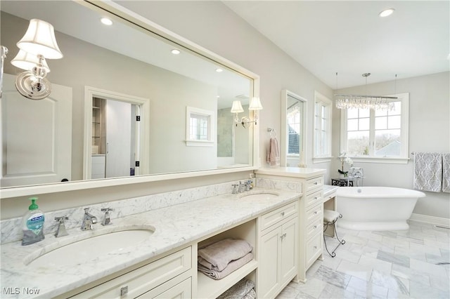 bathroom with double vanity, a soaking tub, a sink, and recessed lighting