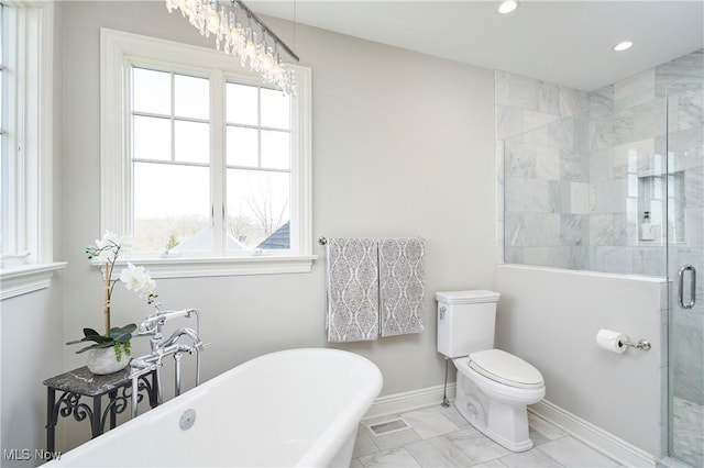 bathroom with toilet, baseboards, a freestanding bath, marble finish floor, and a shower stall