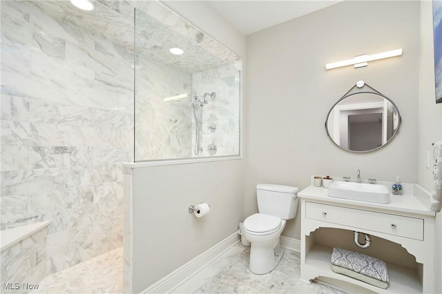 full bathroom featuring toilet, baseboards, a walk in shower, and vanity