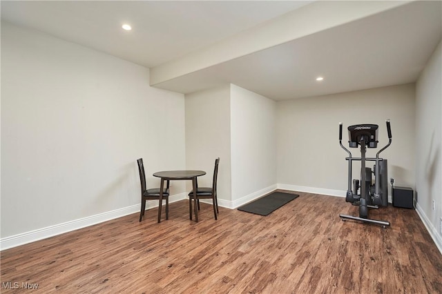 exercise room with baseboards, wood finished floors, and recessed lighting