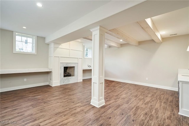 below grade area with recessed lighting, a premium fireplace, baseboards, and wood finished floors