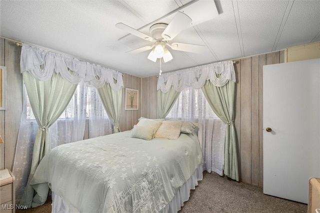 carpeted bedroom with ceiling fan and a textured ceiling