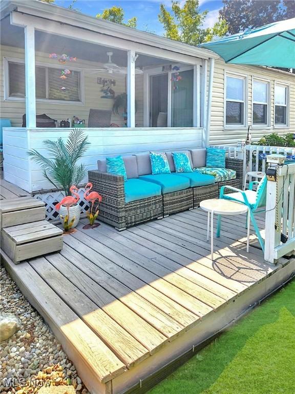 deck featuring outdoor lounge area and a sunroom