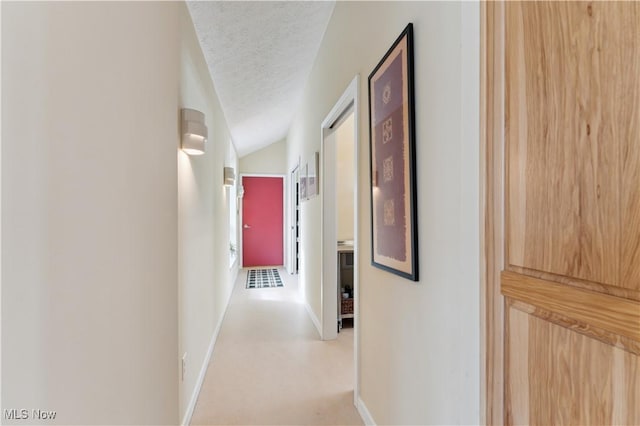 hallway featuring baseboards and a textured ceiling