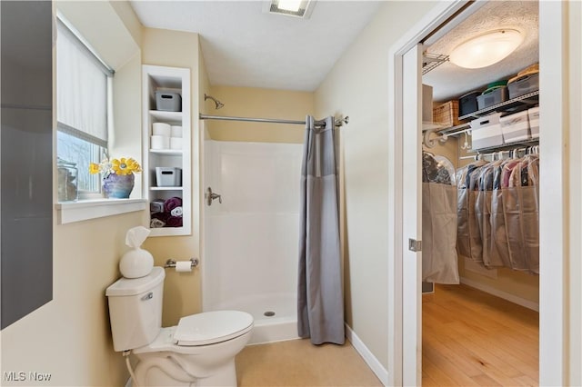 full bath with visible vents, a shower stall, toilet, and wood finished floors