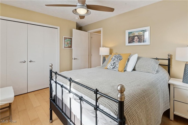 bedroom featuring a closet, wood finished floors, and a ceiling fan