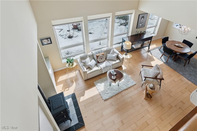 living area with baseboards, an inviting chandelier, and wood finished floors