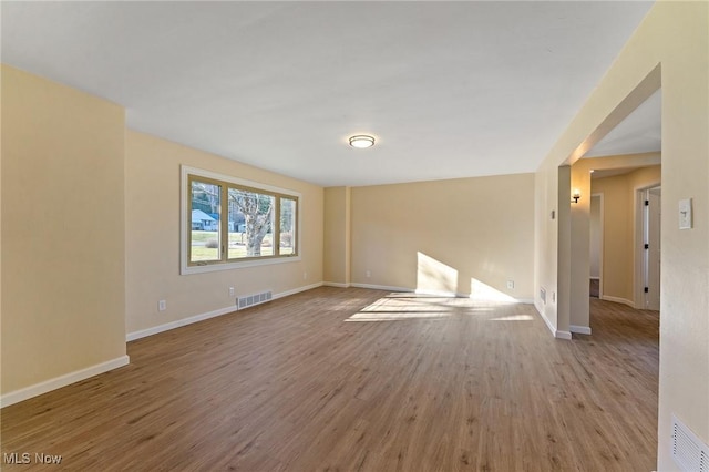 unfurnished room with visible vents, baseboards, and wood finished floors