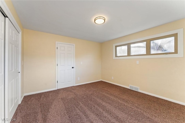 unfurnished bedroom with baseboards, a closet, visible vents, and carpet flooring