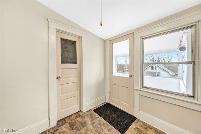 entryway featuring stone finish floor and baseboards