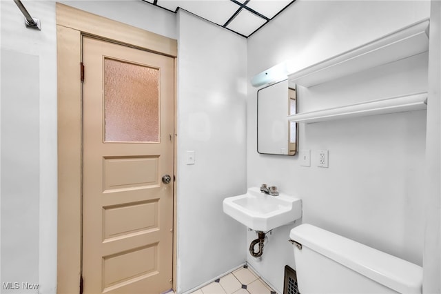 half bath featuring toilet and tile patterned floors