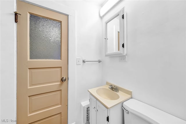 half bathroom with vanity and toilet