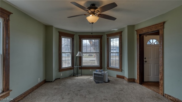 interior space featuring carpet floors, baseboards, and a ceiling fan