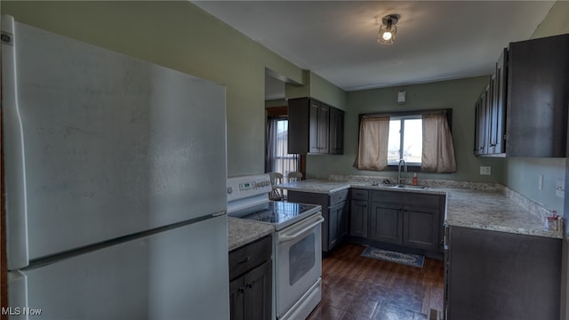 kitchen with a sink, white electric range, and freestanding refrigerator