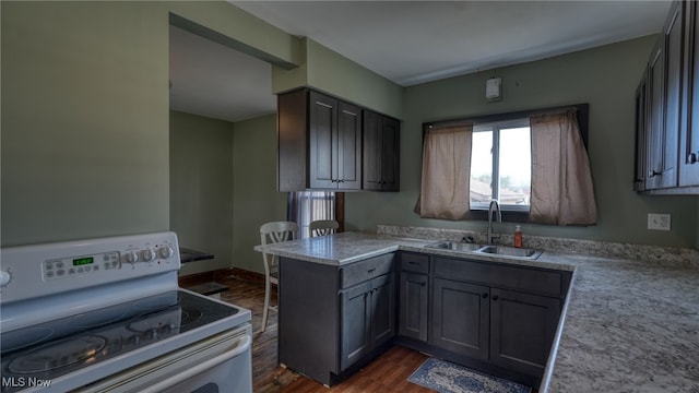 kitchen with gray cabinetry, a peninsula, electric range, a sink, and dark wood finished floors