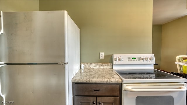 kitchen with light countertops, freestanding refrigerator, and white electric range