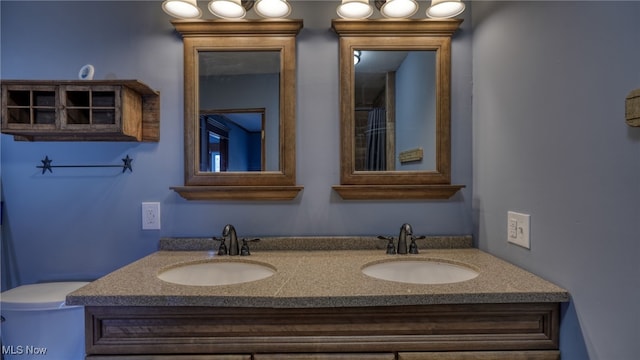 bathroom featuring a sink, toilet, and double vanity