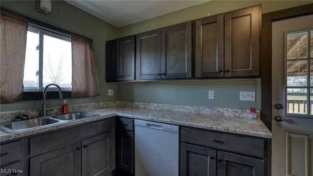 kitchen with dishwasher, light countertops, a sink, and a wealth of natural light