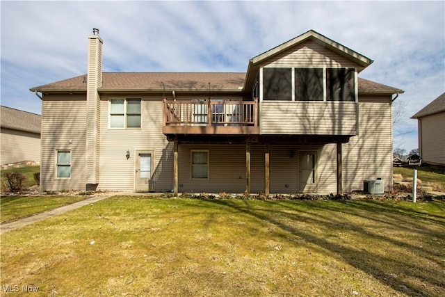 rear view of house featuring cooling unit, a sunroom, a yard, a wooden deck, and a chimney