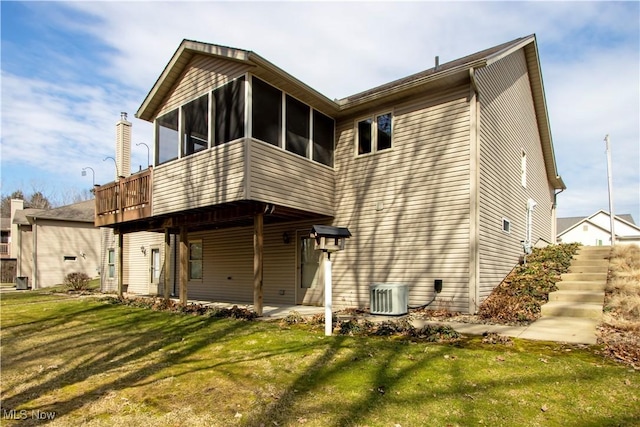 back of house with a yard, a patio area, a sunroom, and central air condition unit