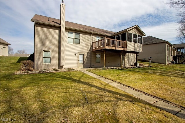 rear view of property featuring a sunroom, a chimney, and a yard