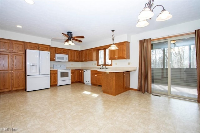 kitchen featuring a peninsula, white appliances, light countertops, brown cabinetry, and decorative light fixtures