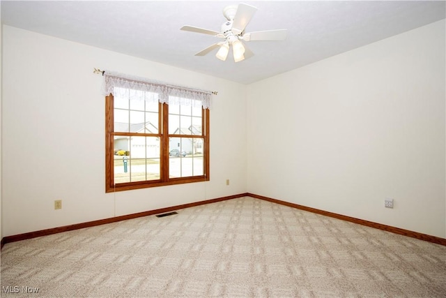 empty room with baseboards, visible vents, ceiling fan, and carpet flooring