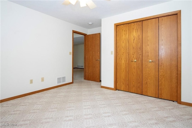 unfurnished bedroom with carpet, a closet, visible vents, and baseboards