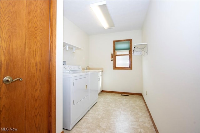 washroom featuring light floors, cabinet space, visible vents, separate washer and dryer, and baseboards