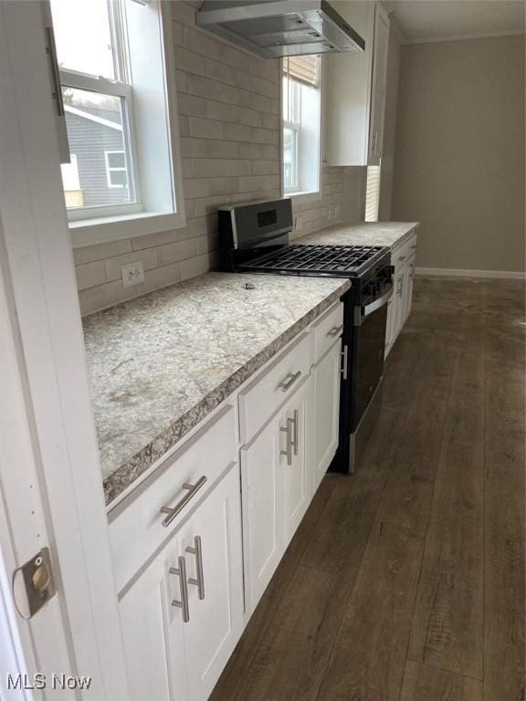 kitchen featuring range with gas stovetop, light countertops, backsplash, dark wood-style floors, and wall chimney exhaust hood