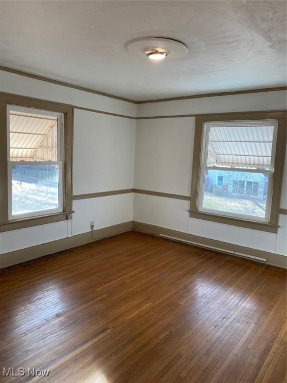 spare room featuring ornamental molding, dark wood finished floors, and baseboards