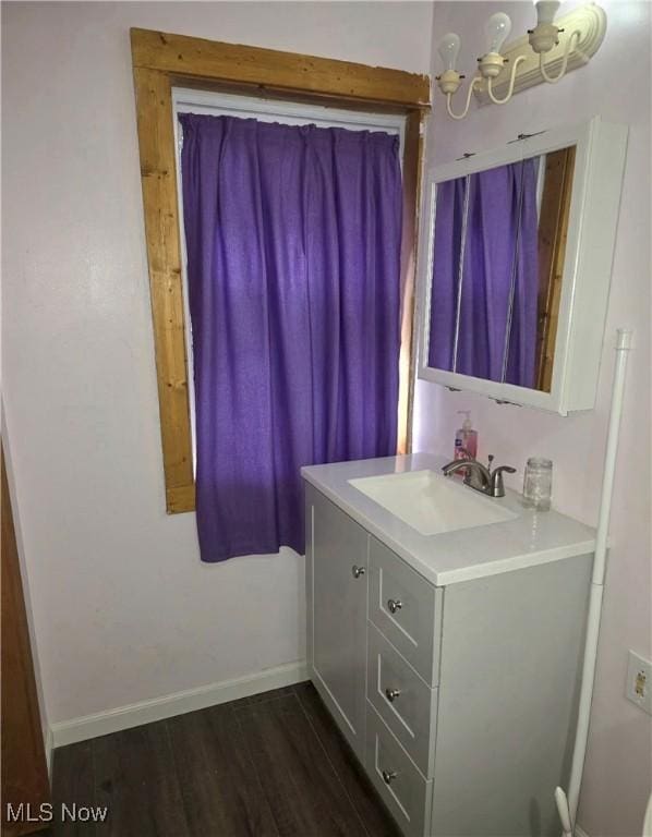 bathroom featuring vanity, baseboards, and wood finished floors