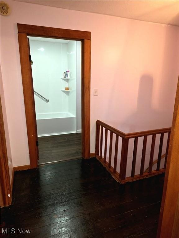 corridor with hardwood / wood-style flooring and baseboards