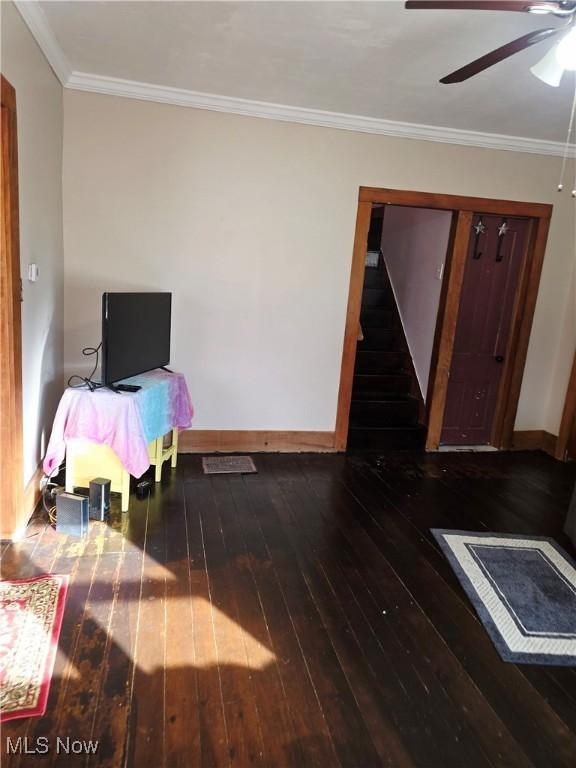 interior space with ornamental molding, stairway, hardwood / wood-style floors, and baseboards