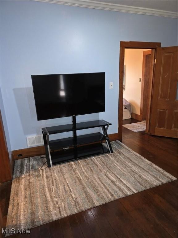 details with visible vents, crown molding, baseboards, and wood finished floors