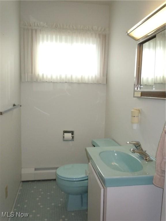 bathroom with toilet, tile patterned floors, a baseboard heating unit, and vanity