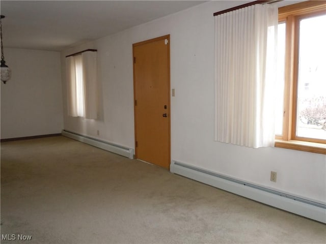 carpeted spare room featuring a baseboard heating unit